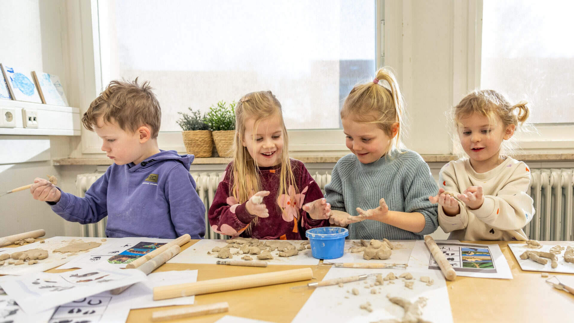 4 kinderen op Kindcentrum Aquamarijn bezig met kleien in de kleuterklas.
